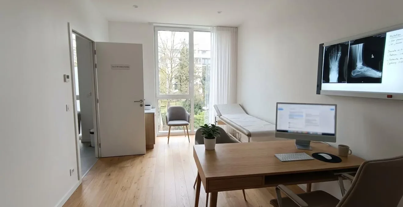 Bureau de consultation médicale moderne avec négatoscope affichant une radiographie de pied, lumière naturelle abondante, environnement professionnel épuré